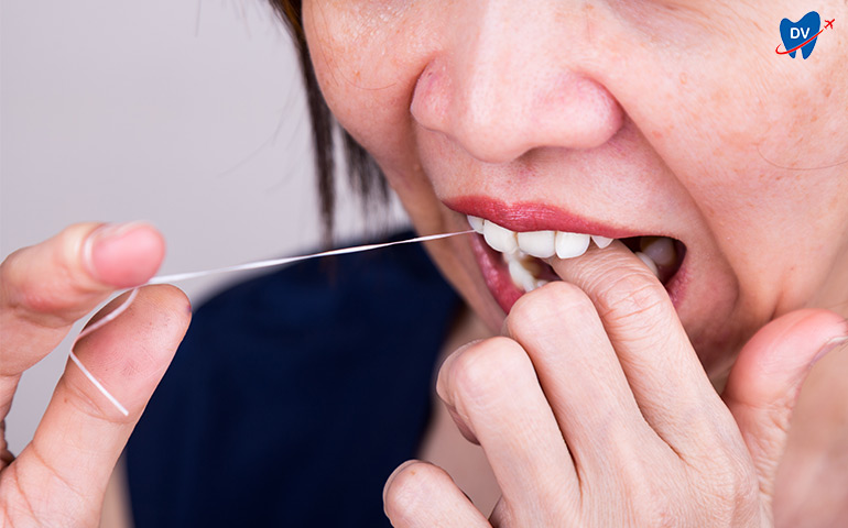 Woman flossing around her teeth