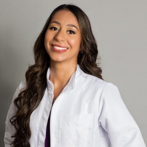 Dr. Ximena Cruz in in a white lab coat smiling at the camera